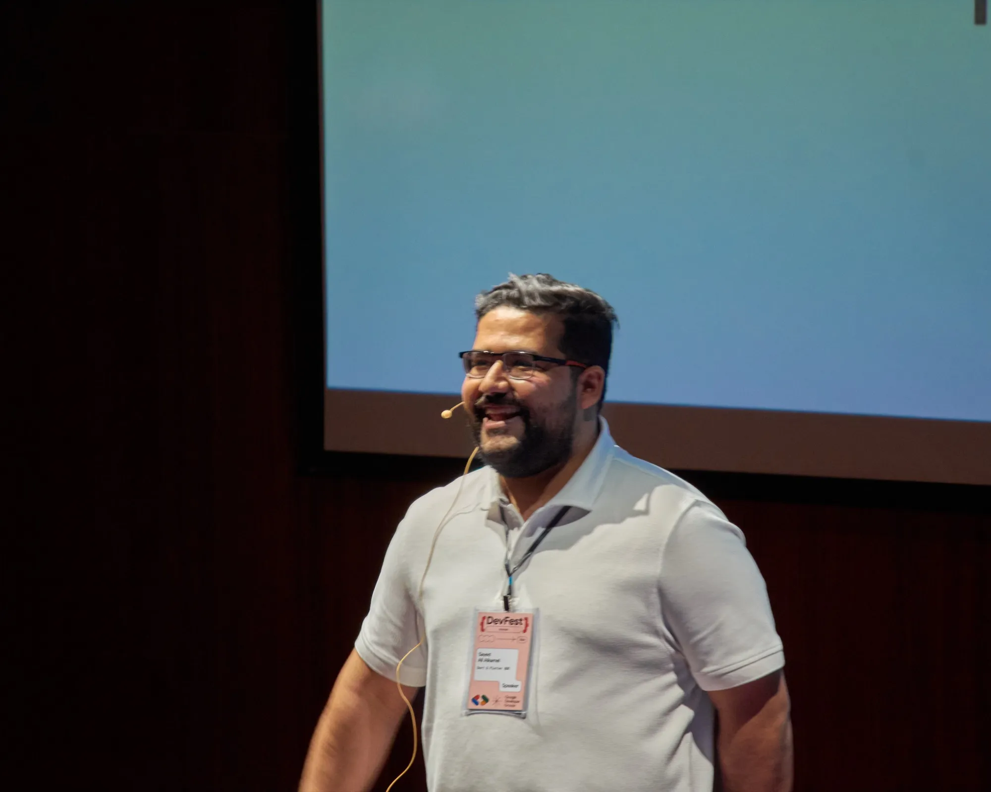 Sayed Ali Alkamel presenting with a headset microphone at DevFest Amman 2024